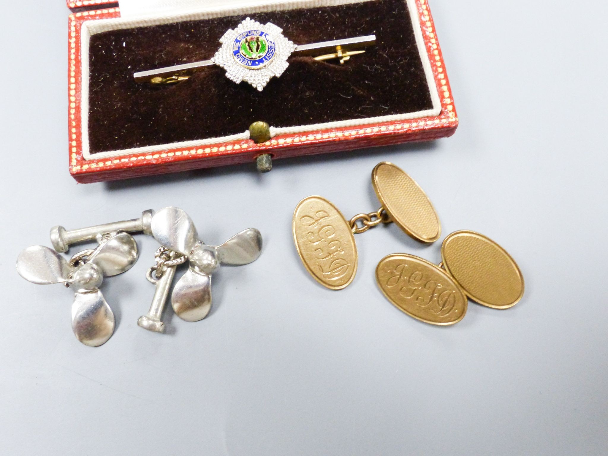 A pair of 9ct gold oval cufflinks with engraved monogram, 11.5 grams, a 14ct, plat and enamel 'Order of the Thistle' bar brooch, 47mm gross 5.1 grams and a pair of base metal propeller cufflinks.